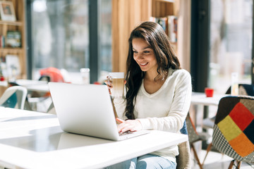 Beautiful brunette enjoying coffee and working