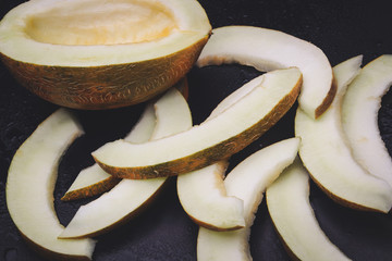 sliced melon slices on a black background