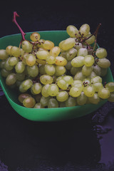 bunch of grapes in a plate on a dark background