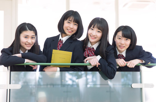 手すりに手を掛けカメラ目線の女子高校生たち