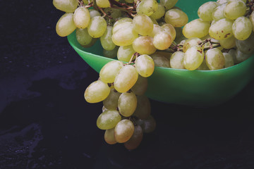 bunch of grapes in a plate on a dark background