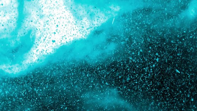 Blue dust particles and paillettes falling and floating over a smoky nebulous white, blue and black background - full hd