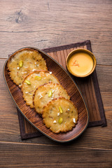 Malpua sweet - Traditional Indian dessert or pancake for festivals, served in plate with rabri/rabdi . selective focus