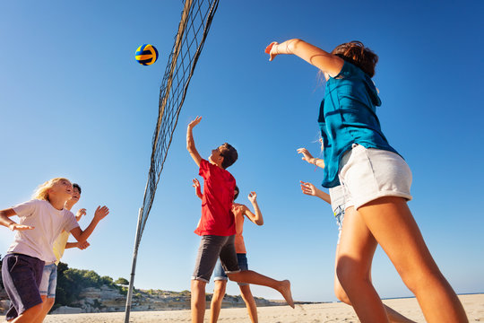 Teens playing volleyball during summer vacation