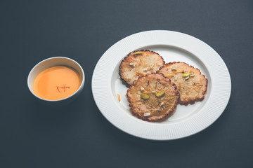 Malpua sweet - Traditional Indian dessert or pancake for festivals, served in plate with rabri/rabdi . selective focus