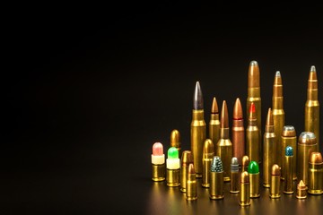 Different types of ammunition on a black background. Sale of weapons and ammunition. The right to hold a gun.