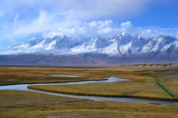 Beautiful Golden Grasslands with river in Tashkurgan with snow covered mountains, Xinjiang, China