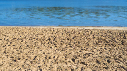 Beach sand and blue water background.