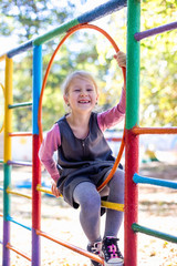Fototapeta premium Little cute girl on the playground in the summer