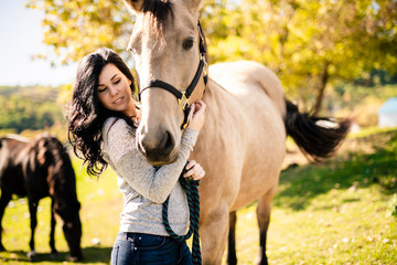 Obraz premium A Portrait of young beautiful woman with brown horse outdoors