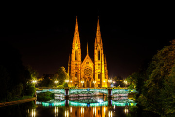 Blick auf die historische Kirche Saint Paul am Fluss Ill in Straßburg bei Nacht, Elsass, Frankreich