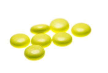 bottle of yellow medical valerian pills on a white background, herb medicine