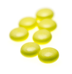 bottle of yellow medical valerian pills on a white background, herb medicine