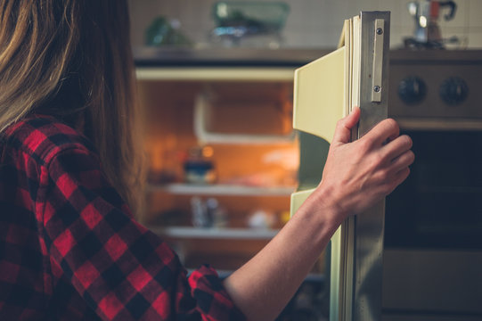 Young woman opening her fridge
