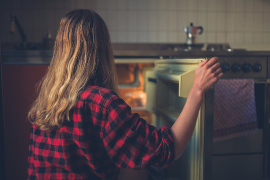 Young woman opening her fridge
