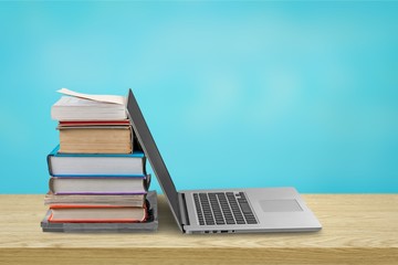 Open laptop near heap of books