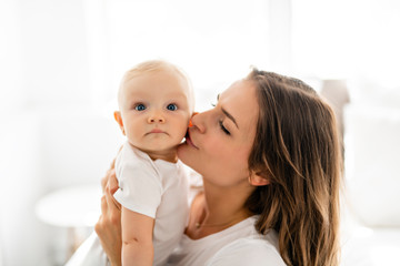 mother with baby on bed having good time