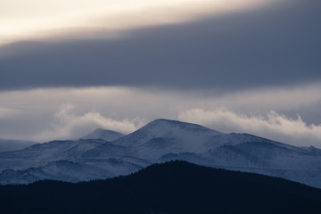 Dramatic winter storm blows over a cold barren landscape at sunset