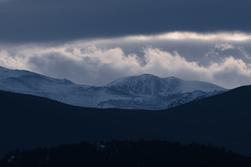 Dramatic winter storm blows over a cold barren landscape at sunset