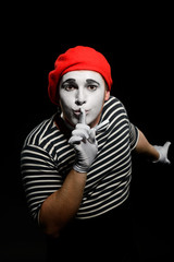 Male mime showing hush sign