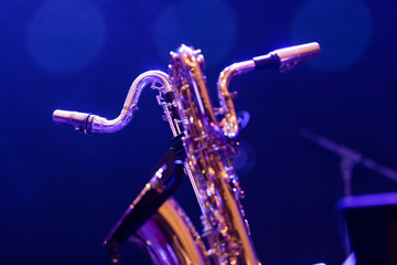 A base clarinet and a baritone saxophone sharing a stage in blue stage lights