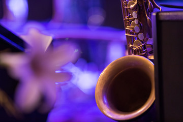 A raw brass saxophone in purple stage lights