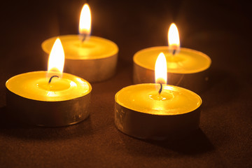 Fototapeta na wymiar Group of burning candles on black background