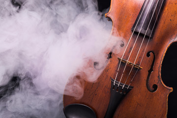 A viola or violin in smoke on a black background © Janisphoto