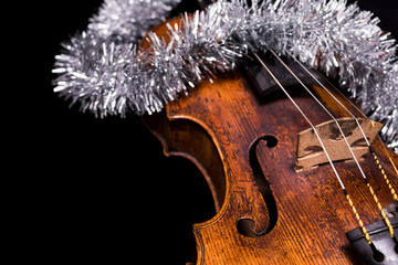 A viola or violin with a christmas ornament on a black background