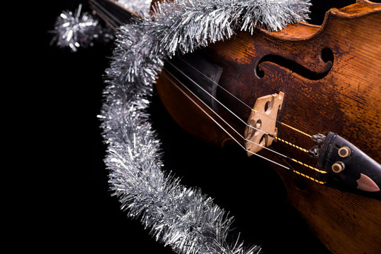 A viola or violin with a christmas ornament on a black background