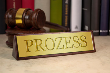 Schreibtischschild mit Richterhammer Prozess