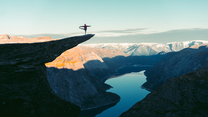 Adventurous man is standing on top of the mountain and enjoying the beautiful view during a vibrant...