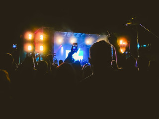 The party, concert concept. Crowd raising their hands and enjoying great rock festival. blur bokeh for background.