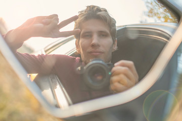 young driver taking a self portrait with professional camera in the car window  f - Powered by Adobe