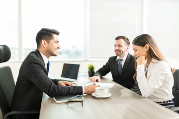 Financial Advisor and Clients Discussing a Contract in an Office