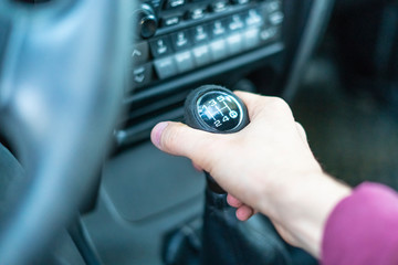 close up driver hand holding car manual trasmission stick f