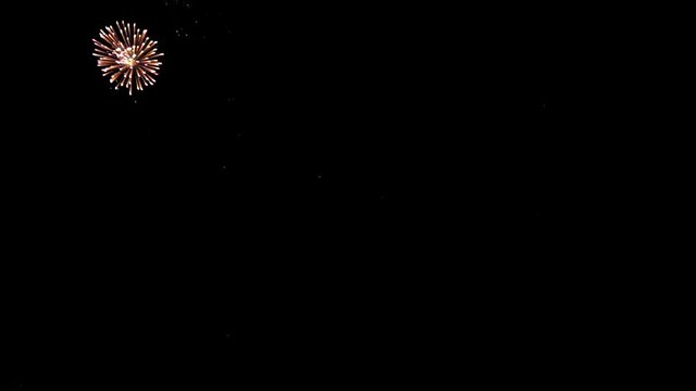 Bright colorful fireworks turn to multicolor bokeh lights at holiday dark summer night.