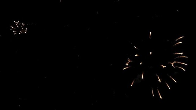 Bright colorful fireworks turn to multicolor bokeh lights at holiday dark summer night.
