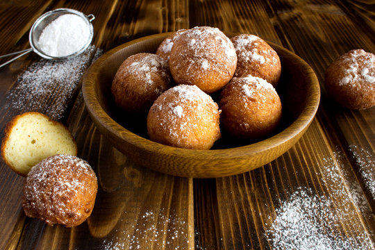 Homemade cottage cheese donuts on the brown wooden background