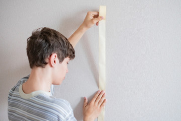 male worker using the masking tape to paint the wall  f