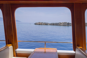 View from the window of the ship at sea. On the horizon, mountains and island