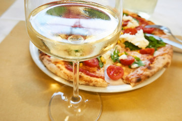 Glass of white wine and pizza Italy