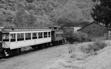 Naklejka na ściany i meble Old railroad cars sitting idle on a track in black and white