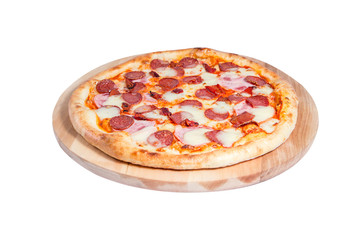 Pizza with salami, bacon, ham and cheese lies on a round wooden board isolated on a white background.
