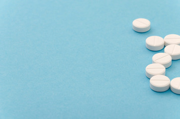 Close-up of handful of pills on blue background