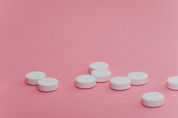  Close-up. A handful of pills on pink background