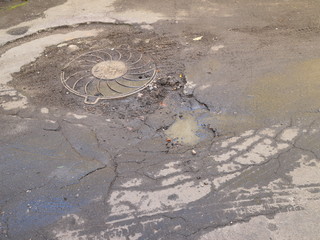 sewer hatch on dirty asphalt