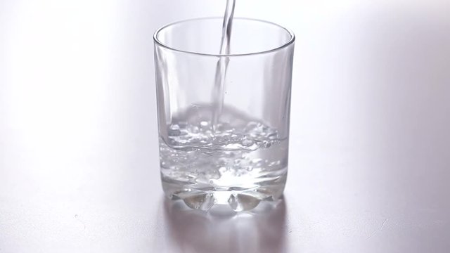 Pours water on glass cup
