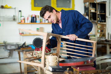 Craftsman repairing chair in workshop