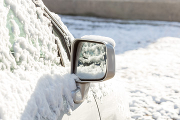 parked car covered with snow during snowing in winter time